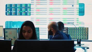 Company employees employing big data used in solving tasks, studying infographics on a huge display. Business analysts reviewing current situation numbers for annual reports. Camera A. photo