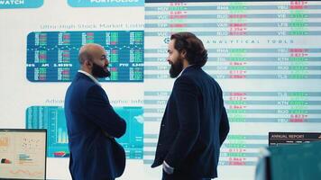 General manager and CEO sharing insight about a new development strategy with data on a big screen, presenting annual infographics to analyze business activity status. Investors team. Camera A. photo