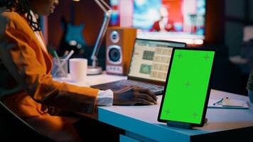 African american business student looking at isolated greenscreen, examining academic software spreadsheet to learn about tax services. Girl using tablet with blank copyspace layout. Camera A. photo