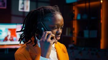 Student calling her professor to discuss about class materials, organizing study schedules and timelines based on online lessons. African american girl talking on smartphone call. Camera B. photo