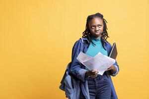 African american woman rolling eyes, working accounting job, looking at report pages, feeling bored, studio background. Young girl frustrated after reading paperwork all day while solving tasks photo