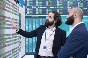 General director discussing with an investor to increase funding for a project, presenting performance metrics and annual data on a big screen. Business associates share strategies. photo