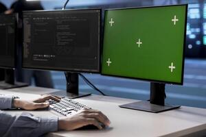 Engineer in server hub using green screen PC to repair equipment storing datasets. Professional using mockup computer to do debugging on rigs doing computational operations photo