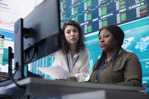 Coworkers team analyzing infographics to provide solutions on an issue affecting the project, looking to finish tasks before deadline. Business employees working together to ensure progress. photo