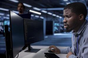 Admin frowning after seeing error in server farm while overseeing supercomputers used for managing databases. IT expert in data center feeling stressed by damaging bugs affecting rackmounts photo