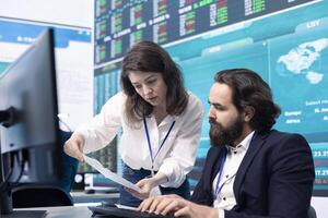 Company employees exchanging project details and big data to help in achieving business objectives, establishing budget and resources. Management team sharing information. photo