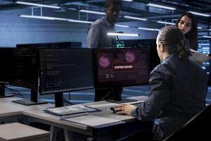 Computer scientist in server hub calling coworkers for help, trying to protect equipment from hacker. IT specialist in data center facility requesting assistance to fix security breach alert photo