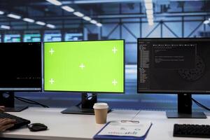 Lines of code running on green screen computers in data center, used for troubleshooting rackmounts in server rows. Close up shot of programming scripts on mockup PC monitors in server room photo