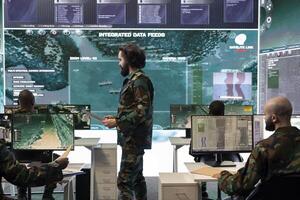 Trooper examining real time reconnaissance data on big screen in military operations base, gather intelligence on hostile vessels trajectory. Army defense program security agent. photo