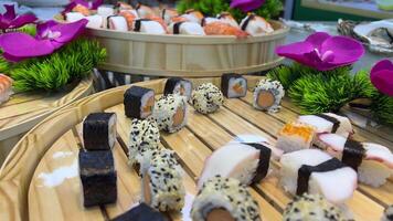 sushi med röd ägg på topp på en trä- bricka. sushi på en trä- bricka video