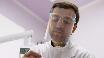 Surgeon operates the patient. Male surgeon doctor in the operating room looking at the patient video