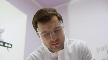 Surgeon performs a complex operation. Male surgeon doctor in the operating room looking at the patient video