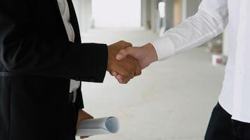 Close up of multiethnic people handshake on construction of building or office. Two engineer shaking hands with deals and congratulations on success video