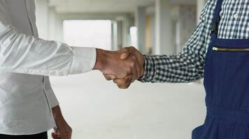 Close up of multiethnic people handshake on construction of building or office. Two engineer shaking hands with deals and congratulations on success video