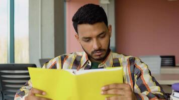 Indian or Pakistani student reads a book in a university library. Preparing to the exams video