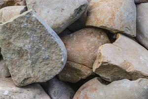 Closeup of smooth river rocks displaying a variety of warm tones photo