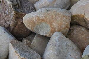 Closeup of smooth river rocks displaying a variety of warm tones and textures photo