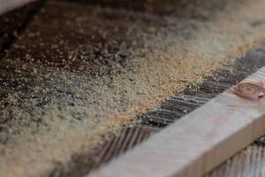 a cut off piece of board with an electric jigsaw on the floor photo