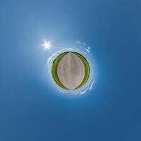 simple tiny planet without buildings in blue sky with beautiful clouds. Transformation of spherical panorama 360 degrees. Spherical abstract aerial view. Curvature of space. photo