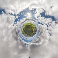 simple tiny planet without buildings in blue sky with beautiful clouds. Transformation of spherical panorama 360 degrees. Spherical abstract aerial view. Curvature of space. photo