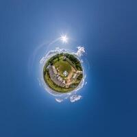 simple tiny planet without buildings in blue sky with beautiful clouds. Transformation of spherical panorama 360 degrees. Spherical abstract aerial view. Curvature of space. photo