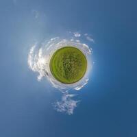 simple tiny planet without buildings in blue sky with beautiful clouds. Transformation of spherical panorama 360 degrees. Spherical abstract aerial view. Curvature of space. photo