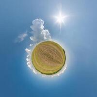 simple tiny planet without buildings in blue sky with beautiful clouds. Transformation of spherical panorama 360 degrees. Spherical abstract aerial view. Curvature of space. photo