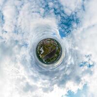 simple tiny planet without buildings in blue sky with beautiful clouds. Transformation of spherical panorama 360 degrees. Spherical abstract aerial view. Curvature of space. photo