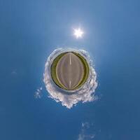 simple tiny planet without buildings in blue sky with beautiful clouds. Transformation of spherical panorama 360 degrees. Spherical abstract aerial view. Curvature of space. photo