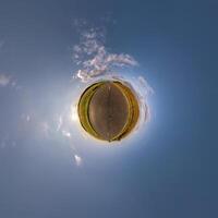 simple tiny planet without buildings in blue sky with beautiful clouds. Transformation of spherical panorama 360 degrees. Spherical abstract aerial view. Curvature of space. photo