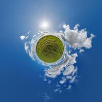 simple tiny planet without buildings in blue sky with beautiful clouds. Transformation of spherical panorama 360 degrees. Spherical abstract aerial view. Curvature of space. photo