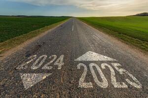 numbers 2024, 2025 on asphalt road highway with sunrise or sunset sky background. concept of destination in future, freedom, work start, run, planning, challenge, target, new year photo
