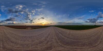 hdri 360 panorama on gravel road among fields in spring nasty evening before sunset in equirectangular full seamless spherical projection, for VR AR virtual reality content photo