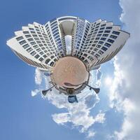 abstract swirling tiny planet spherical panorama of multi-storey buildings of skyscrapers of a residential complex in the form of a butterfly in blue sky photo