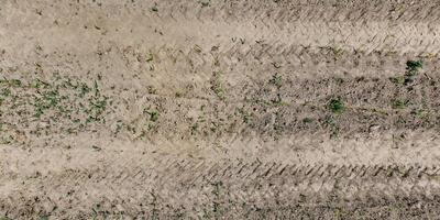 view from above on texture of dry muddy road with tractor tire tracks in countryside photo