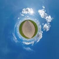 simple tiny planet without buildings in blue sky with beautiful clouds. Transformation of spherical panorama 360 degrees. Spherical abstract aerial view. Curvature of space. photo