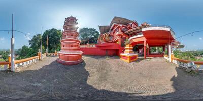 full hdri 360 panorama near hindu maruti temple of ape goddess hanuman on high mountain in jungle among palm trees in Indian tropic town in red color in equirectangular projection. VR AR content photo
