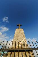 sillhoette of stone grave cross against the background of a blue evening sky with clouds photo