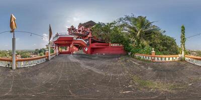 full hdri 360 panorama near hindu maruti temple of ape goddess hanuman on high mountain in jungle among palm trees in Indian tropic town in red color in equirectangular projection. VR AR content photo