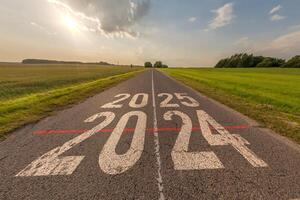 numbers 2024, 2025 on asphalt road highway with sunrise or sunset sky background. concept of destination in future, freedom, work start, run, planning, challenge, target, new year photo