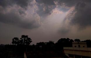 Sparkling beams of light extending from clouds during the rainy season in an Indian villgae photo