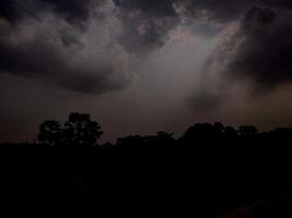 Sparkling beams of light extending from clouds during the rainy season in an Indian villgae photo