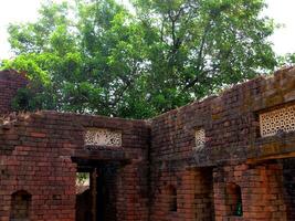 A village farmhouse with an open roof at the centre with brick walls photo