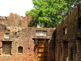 A village farmhouse with an open roof at the centre with brick walls photo