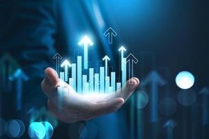 Success and growth of Investment and financial concept. Businessman holding digital chart arrows up and graph corporate future growth plan on network structure of business. photo