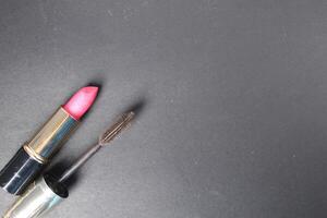 Red pink lipstick and mascara on a black background with space for the text moka copyspace. How to Wear Makeup for Every Day photo