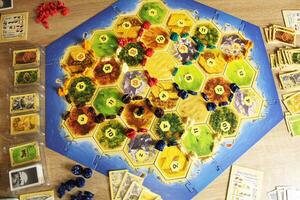 Mozyr, Belarus, April 01 2024. A catan board game is the process of a four-player game yellow, red, blue, green components, token players on the playing field. Dislocation of Players Game Strategy photo