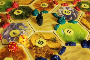 Mozyr, Belarus, April 01 2024. A catan board game, the green and blue tiles of the players are displayed on the field next to the desert hex with bandits. Rules for placing a rogue token. Hexa Digit photo