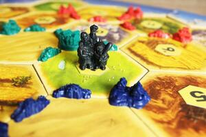 Mozyr, Belarus, April 01 2024. A catan board game figure of robbers on the playing field. Strategic Decision photo