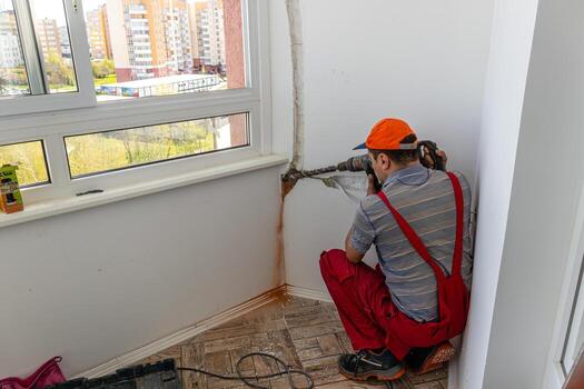 air conditioning system men is working drilling a wall Lviv Ukraine 08.04.2024 photo